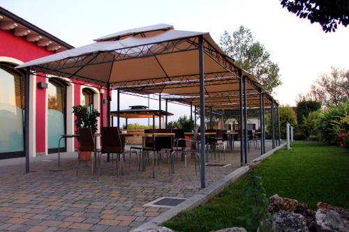 a patio with tables and chairs under a pavilion at Albergo Delle Industrie in Casalmaggiore