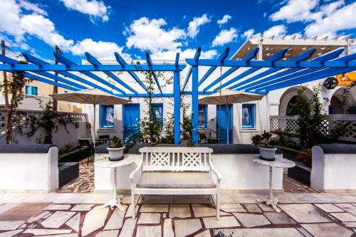 a white bench sitting on a patio under a pergola at Laokasti Villas in Oia