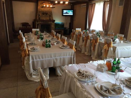 a group of tables with white table cloths and chairs at Hotel Grant in Kharkiv
