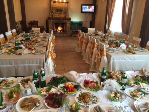 a long table with plates of food and a fireplace at Hotel Grant in Kharkiv
