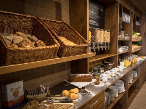 a bakery with bread and pastries on a shelf at Alpenstadthotels in Bad Reichenhall