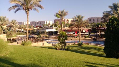 um resort com um parque com palmeiras e uma piscina em Gazzar inn rehab9 no Cairo