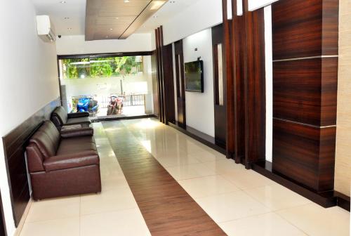 a living room with a leather couch and wooden walls at Emporium Hotel in Mangalore