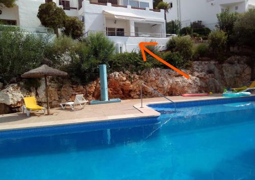 an orange arrow is pointing to a swimming pool at Beach Suite Playa Cala dor in Cala d´Or