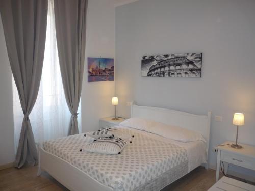 a white bedroom with a bed and a window at My Bed Vatican Museum in Rome