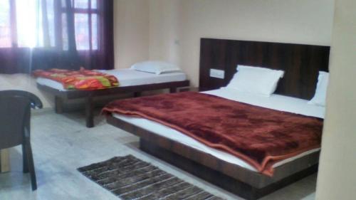 a bedroom with two beds and a table and a bed at Laxmi Mahal in Udaipur