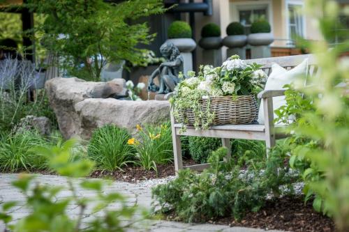 a wicker basket on a bench in a garden at Hotel Riedenburg in Bad Füssing