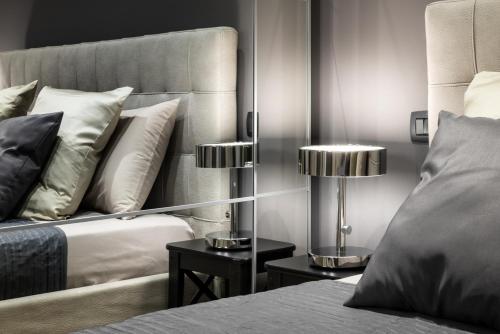 ミラノにあるレオナルド デュプレックス アパートメントのベッドルーム1室(ベッド1台、テーブルの上にランプ付)