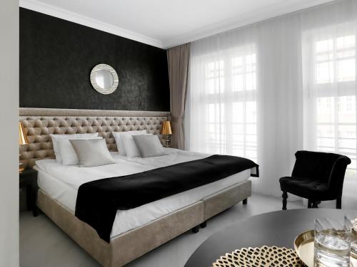 1 dormitorio con 1 cama grande y 1 silla en Lavoo Boutique Apartments, en Gdansk