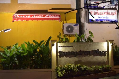 a sign in front of a building with plants at Duangdren Place in Chiang Mai