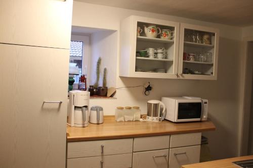 cocina con armarios blancos y encimera con microondas en Ferienhaus-Grambzow, en Grambzow