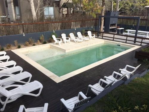 a pool with white lounge chairs and a bunch ofitures at Aguamansa in Las Gaviotas