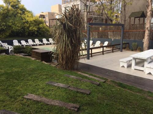 a group of white chairs and a table and grass at Aguamansa in Las Gaviotas