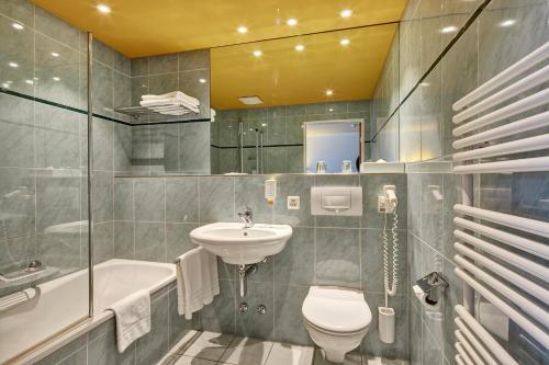 La salle de bains est pourvue d'un lavabo, de toilettes et d'une baignoire. dans l'établissement Hotel Berchtold, à Burgdorf