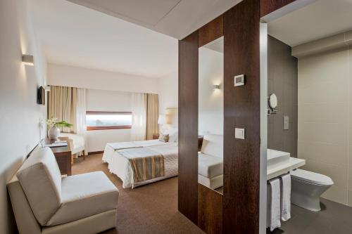 a hotel room with a bed and a bathroom at Sao Felix Hotel Hillside & Nature in Póvoa de Varzim
