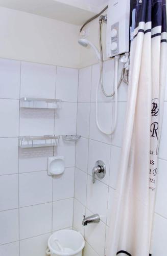 a bathroom with a shower and a toilet at Ezeniel's Place at Horizons 101 Condominium in Cebu City