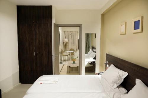 a bedroom with a large white bed and a bathroom at Hotel La Villette in Antananarivo