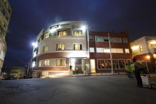 a building at night with people standing in front of it at Hotel La Villette in Antananarivo
