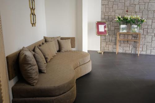 a brown couch sitting in a living room at Hotel La Villette in Antananarivo