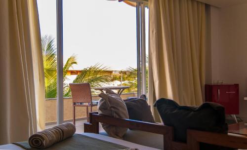 a room with a large sliding glass door to a patio at Ravenala Hotel Boutique in Canoa Quebrada