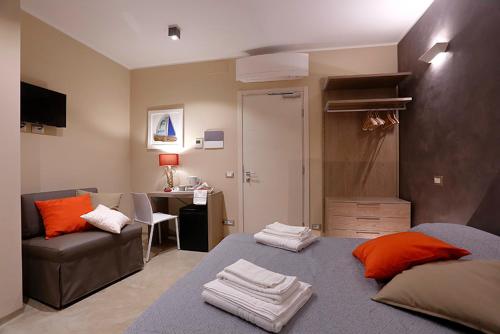 a bedroom with a bed and a couch and a desk at Gaslini vicinissimo - Casa dello Zio in Genoa