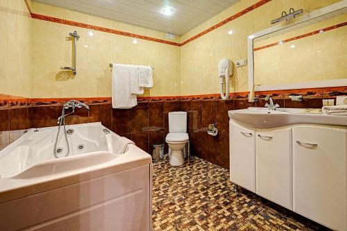 uma casa de banho com uma banheira, um lavatório e um WC. em Tver Hotel em Tver