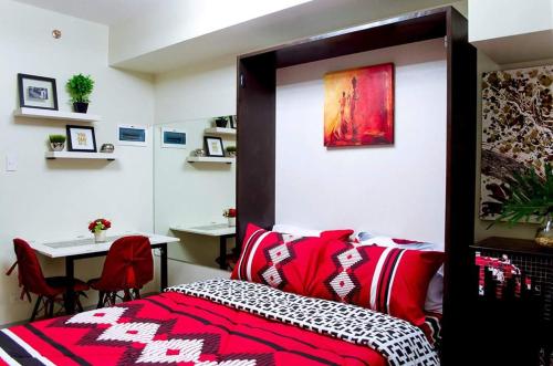 a bedroom with a bed and a table and a desk at Ezeniel's Place at Horizons 101 Condominium in Cebu City