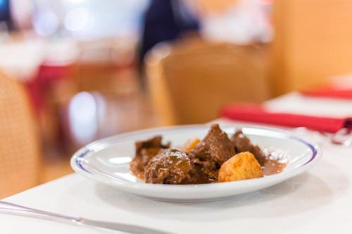a white plate of food on a table at Hotel Club Regina E Fassa in Mazzin