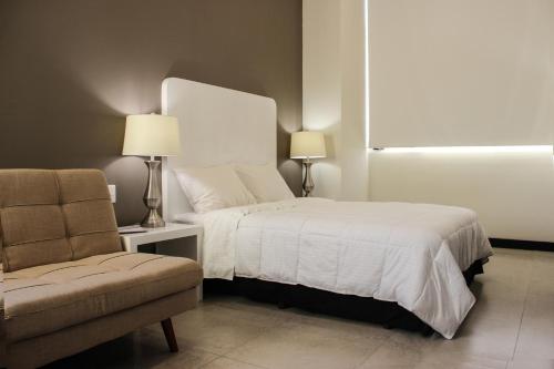 una camera con letto, divano e sedia di Laviu B&B Luxe Suites a Puebla