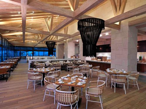 a restaurant with tables and chairs and a bar at Unico Hotel Riviera Maya Adults Only in Akumal