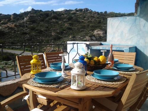 una mesa de madera con platos y cuencos de comida. en Casa Asia Residence Barrettini, en La Maddalena