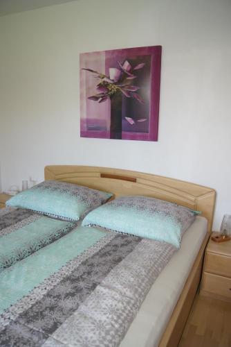 a bed with two pillows and a picture on the wall at Haus Rainer in Innsbruck