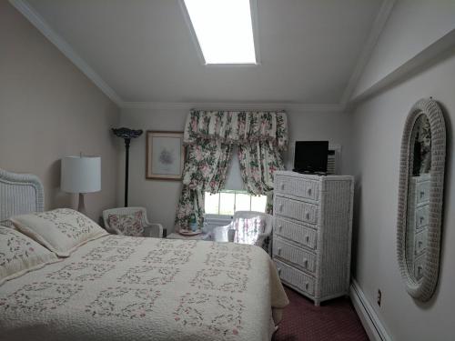 een slaapkamer met een bed, een dressoir en een raam bij Inn At The Park - The Cottage in Cape May