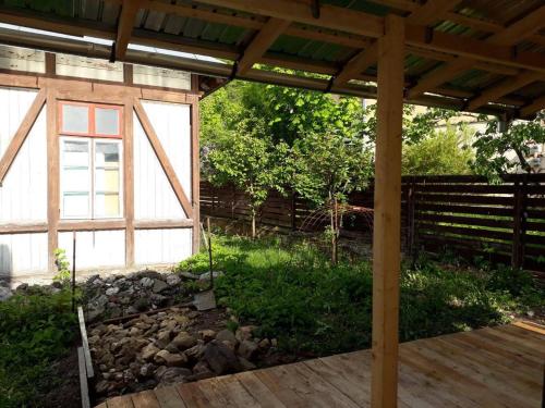 a wooden pergola with a rock wall in a yard at Casa Oprea in Sinaia