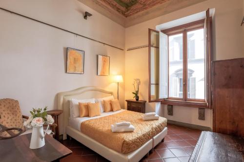 1 dormitorio con cama y ventana en Firenze Rentals Suite Art, en Florencia