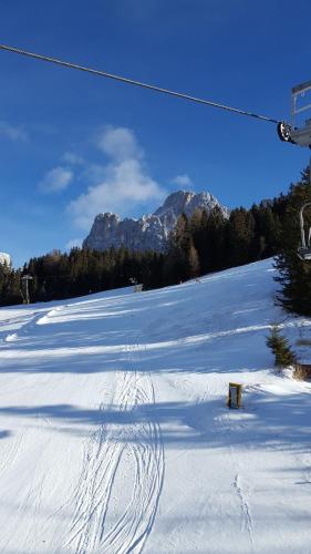 a snow covered ski slope with a ski lift at Kellnerhof in Nova Levante