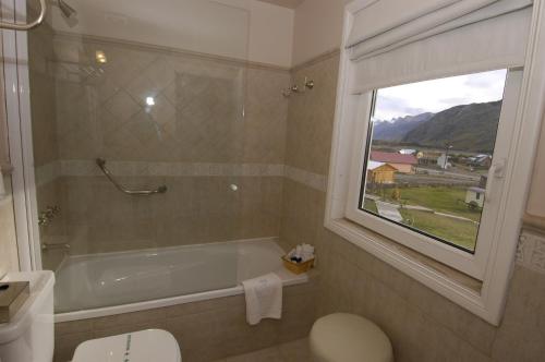 baño con bañera y ventana en Lo de Tomy en El Chaltén