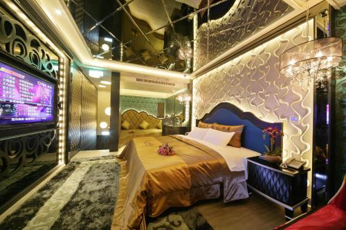 a bedroom with a large bed and a tv at Chusha Motel in Gongguan