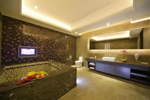 uma casa de banho com uma banheira com uma tigela de fruta em Chusha Motel em Gongguan