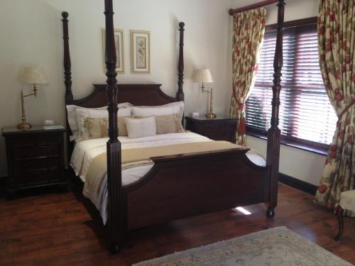 a bedroom with a large bed and a window at Roman Retreat in Cape Town