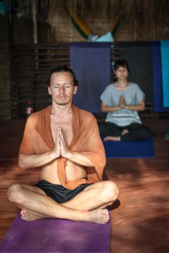 two men are sitting in a yoga class at Drishti yoga international in Patnem