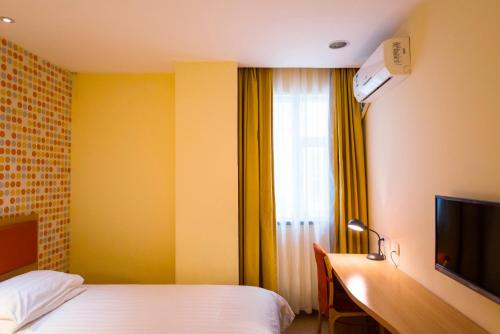 a hotel room with a bed and a desk and a television at Home Inn Taiyuan North Xinjian Road in Taiyuan