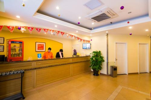 a restaurant with two people standing at a counter at Home Inn Taiyuan North Xinjian Road in Taiyuan