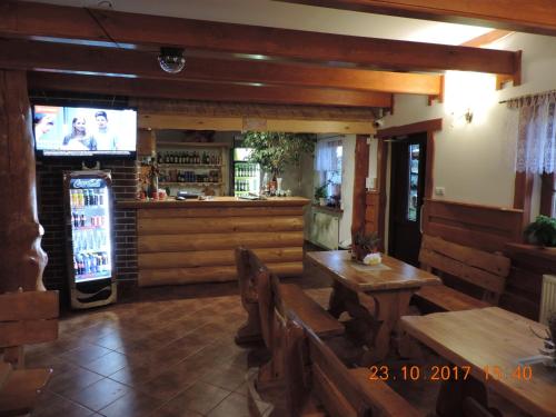 a restaurant with a bar with a television and benches at GAMP Paweł Sawicki in Kleszczele