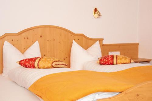 two beds with pillows on them in a bedroom at Haus Alblitt in Kappl