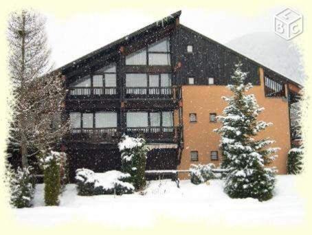 un grand bâtiment avec de la neige devant lui dans l'établissement Studio Residence Le Stella, à Ancelle