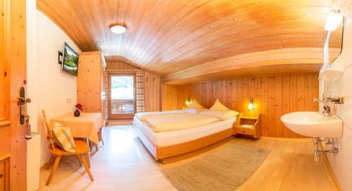 a bedroom with a large bed and a sink at Haus Sonnenseit'n in Neustift im Stubaital