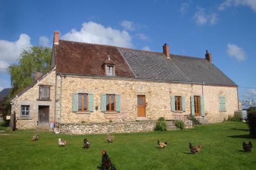 um grupo de galinhas em pé em frente a uma casa em Maison d'hôtes La Roulotte des 4 Saisons em Sazeray