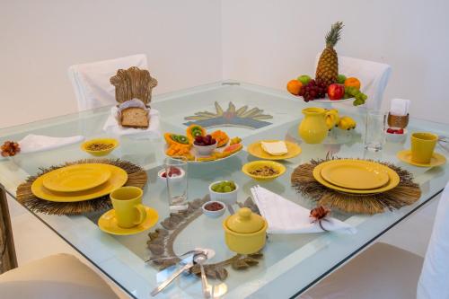 ein Tisch mit gelbem Geschirr und Obst darauf in der Unterkunft Pousada Casa de Paraty in Paraty