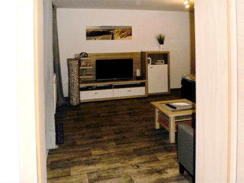 a living room with a television and a table at Ferienwohnung Anke - Apartment 3c in Heinsberg
